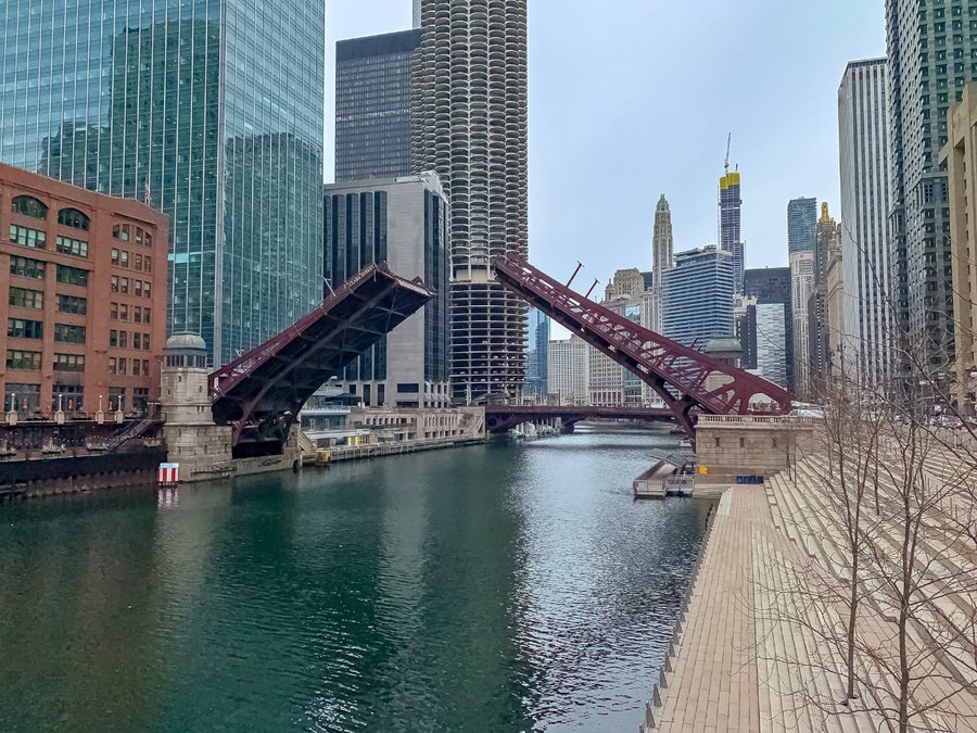 Raised bascule movable bridges over the Chicago River with the downtown skyline behind.