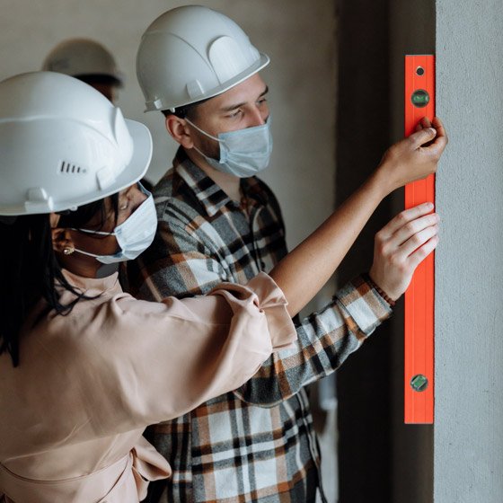 HBM team members checking work with a level on a job site