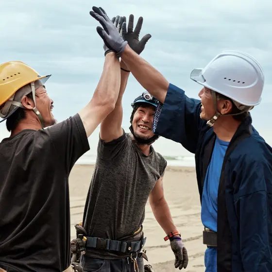 HBM Engineering field team sharing a high-five — emphasizing teamwork and safety culture